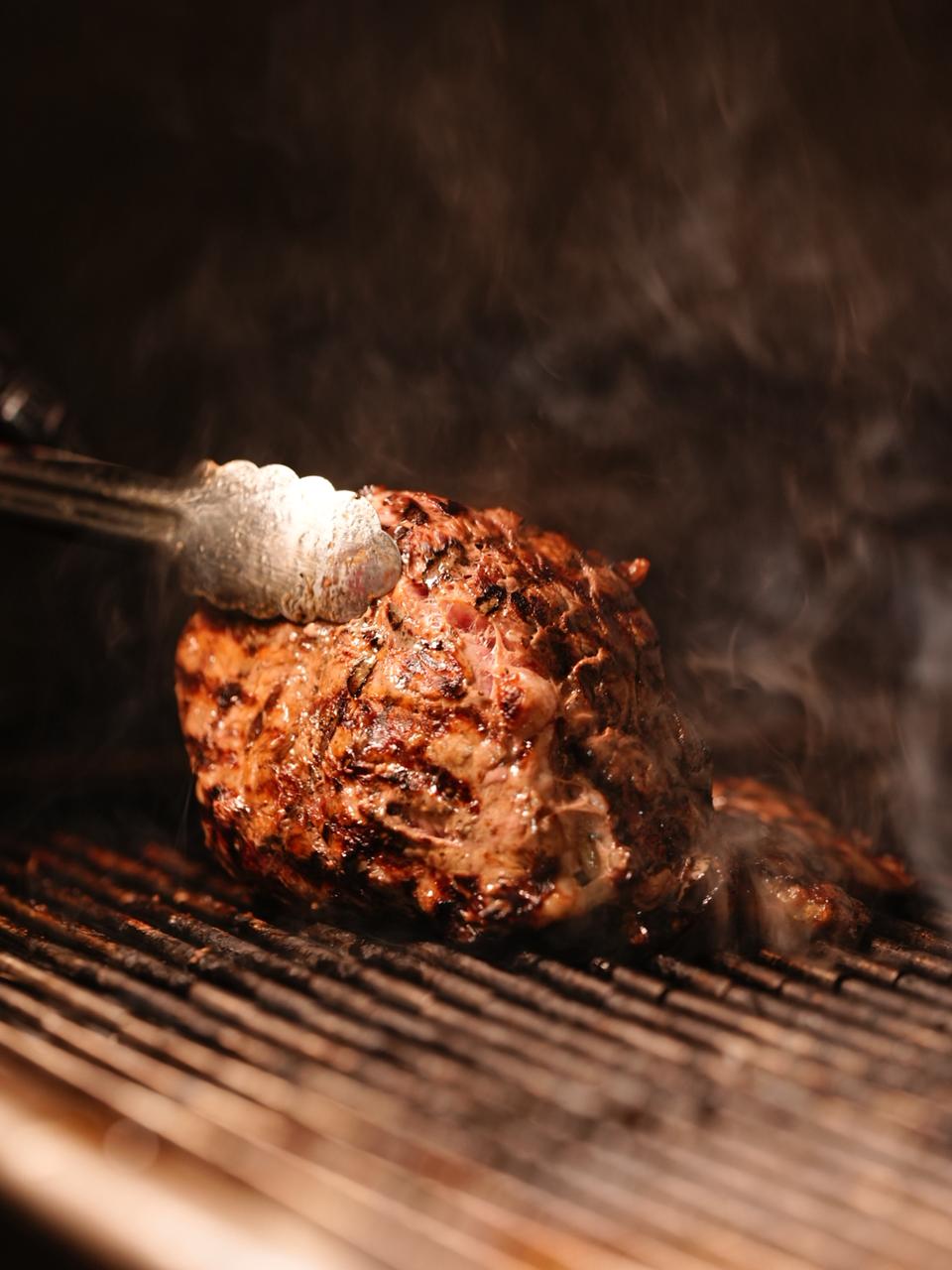 Meat cooking on the grill at Corner Pizza and Grill